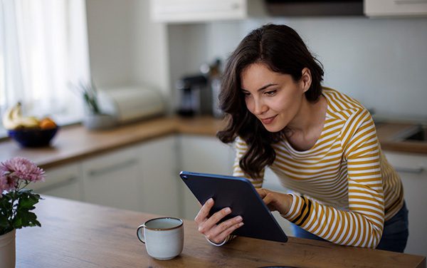 Hopeful adoptive mother reading an adoption blog in her kitchen