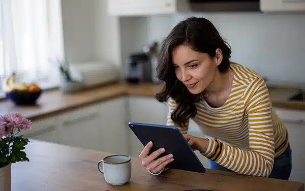 Hopeful adoptive mother reading an adoption blog in her kitchen