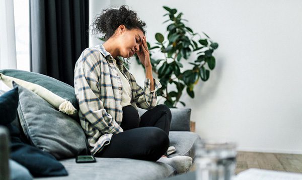 Black pregnant woman in her living room feeling tired and exhausted