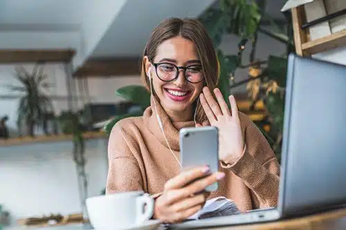 Smiling birth mother waves while on a FaceTime call with her child's adoptive parents
