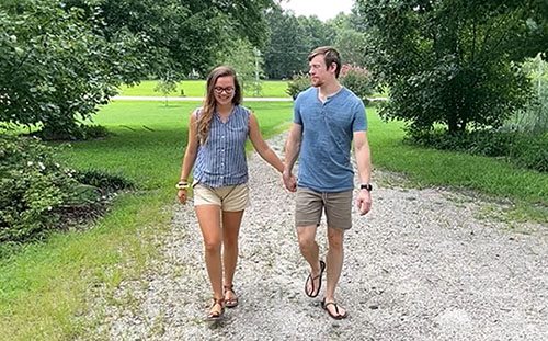 Maggie and Blake, hopeful adoptive parents in North Carolina, hold hands while walking together