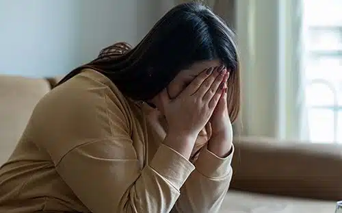 Sad woman sitting on a sofa in the living room