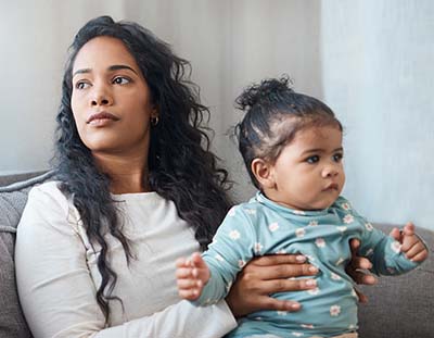 unhappy woman holding child and thinking about adoption