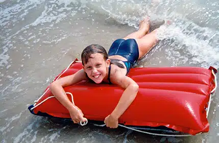 Emily having fun at the ocean as a child