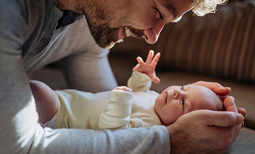 Close up of adoptive father cuddling his infant son