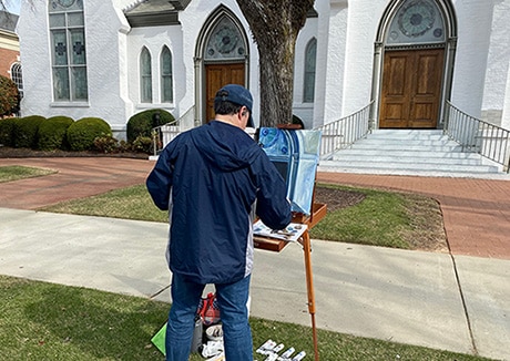 Hopeful adoptive dad Chad painting a church door al fresco