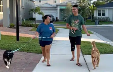 Rachelle and Trung enjoy chatting together while taking their dogs on a walk around the neighborhood