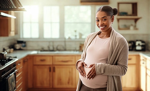 Smiling young pregnant woman in her kitchen