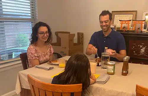 Hopeful adoptive parents Travis and Amanda eating dinner with their daughter