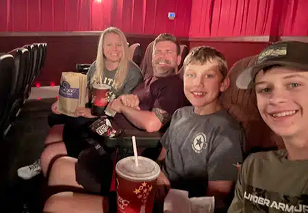 Max and Sarah with their two sons at a movie theater