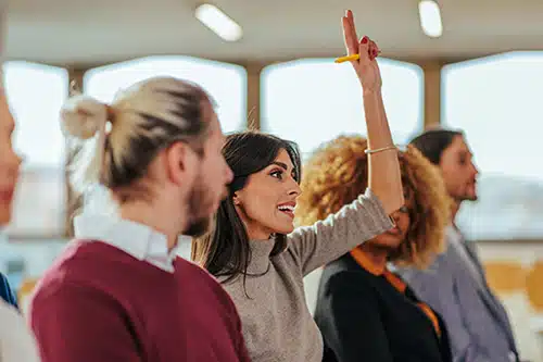 Woman raises her hand during an informational adoption meeting