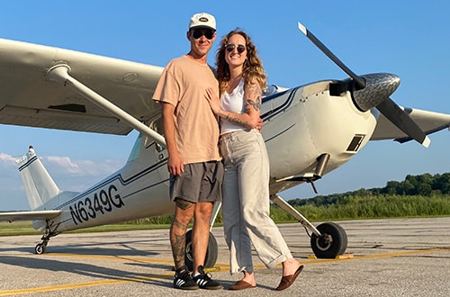 Corbin and Paige pose by the plane Corbin flies