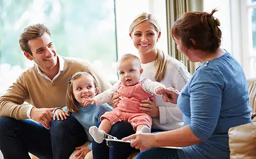 Happy social worker chats with an adoptive family during one of their post placement adoption visits