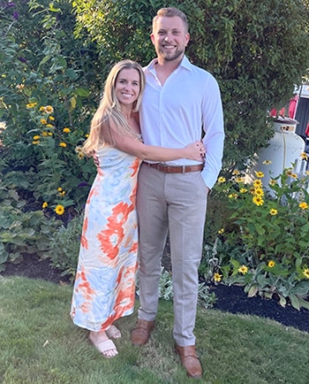 Hopeful adoptive parents Brady and Elijah dressed up for an event, posing for the camera by a garden