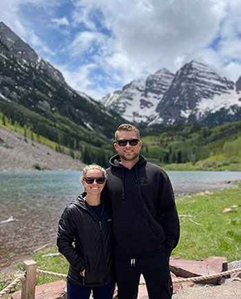 Brady and Elijah pose by mountain on a vacation