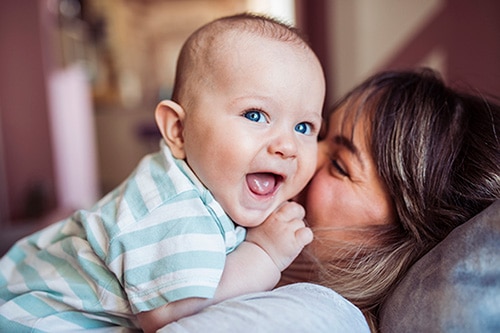 An adoptive mother having fun with her infant son